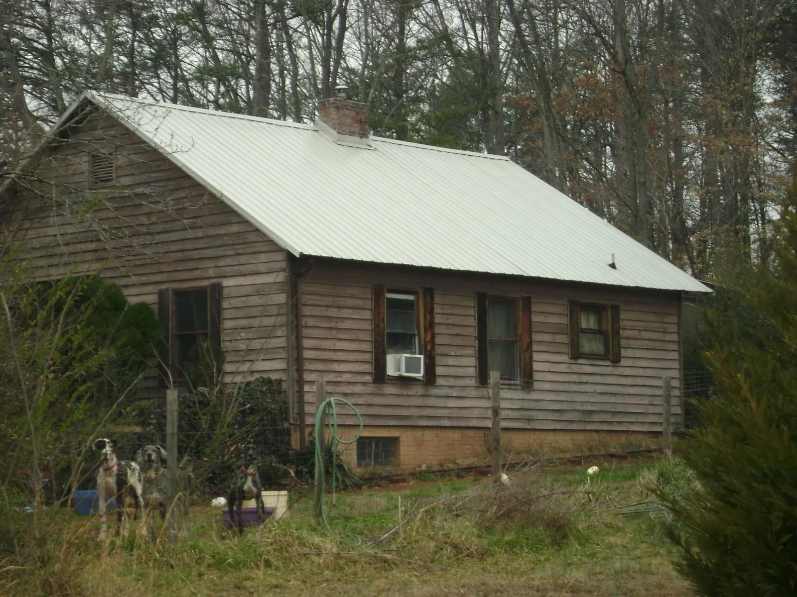 White metal roof on an old wood sided farmhouse, from a Metal Roof Installation job in Guthrie